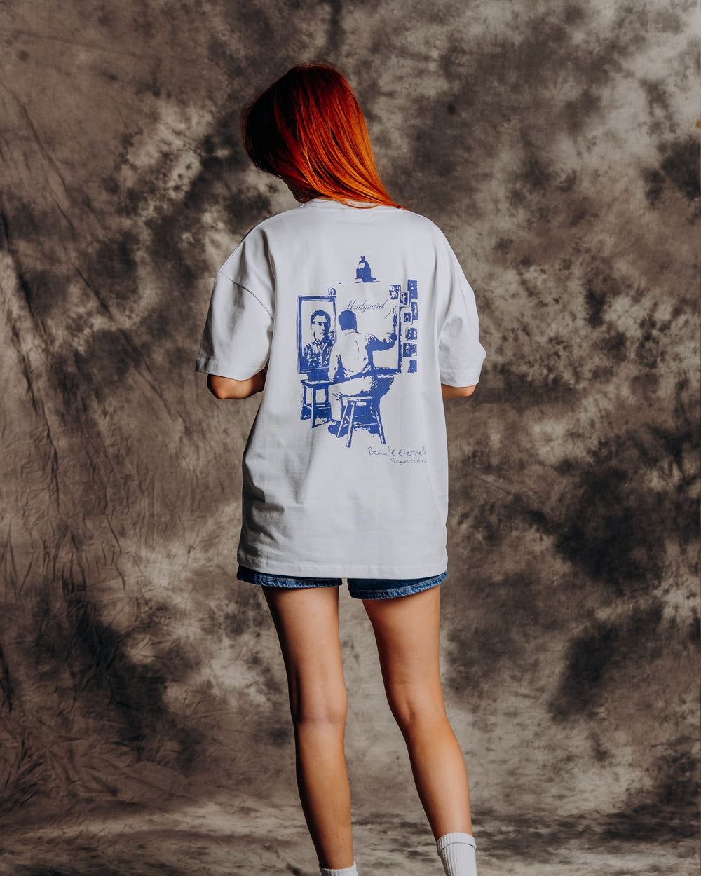 Oversized white graphic t-shirt model back view showing print